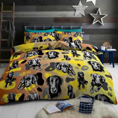 A bedroom scene with a bed dressed in dog-themed bedding.