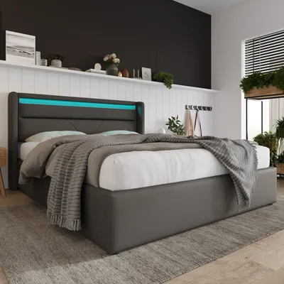 A modern bedroom with a bed featuring LED lighting.