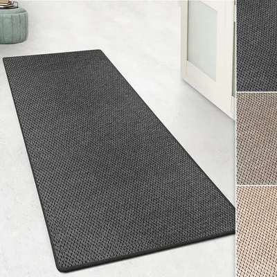 A dark gray rug with a textured pattern is laid out on a light-colored floor, with a partially open white door in the background. Small inset images show the rug in different color variations.