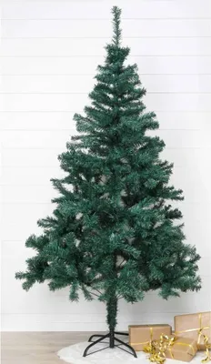 A green artificial Christmas tree on a white rug with gift boxes in the background.