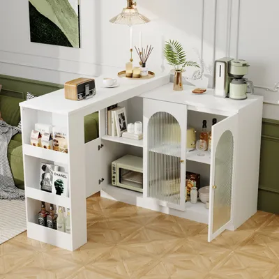 A white bar table with storage is set up in a living room or dining area, with decorative items and appliances on it.