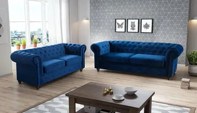 A living room scene with two blue velvet Chesterfield sofas and a coffee table.