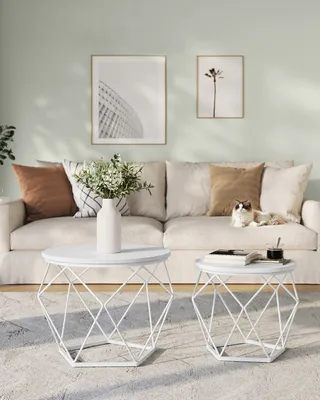 A living room scene with a sofa, coffee tables, and wall art.