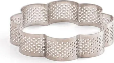 A silver, flower-shaped tart mold with perforations.