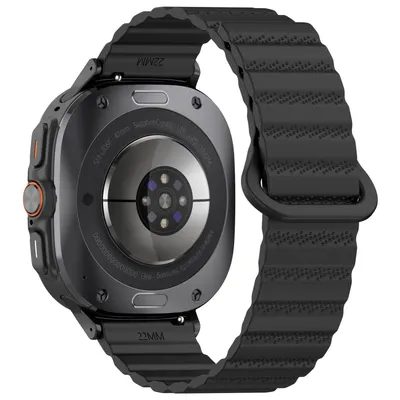 The back of a black smartwatch with a black silicone band.