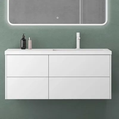 A white bathroom vanity with a sink and faucet against a green wall.