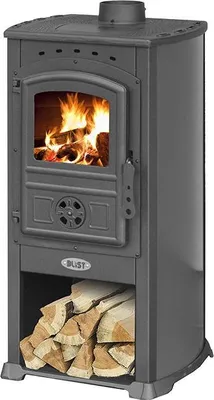 A dark gray wood-burning stove with a fire burning inside and a stack of firewood below.