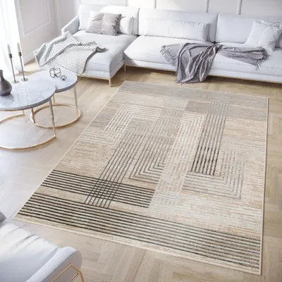 A modern living room with a sectional sofa, coffee tables, and a geometric rug.