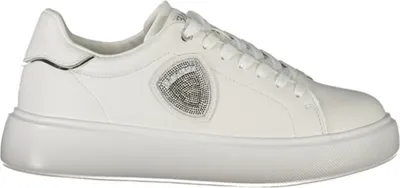 A white sneaker with a jeweled logo on a white background.