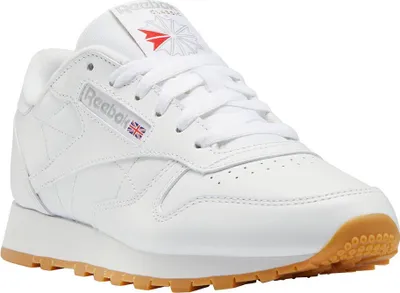 A white Reebok Classic leather sneaker with a gum sole, shown from a side angle.