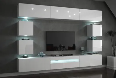 A modern white media console and shelving unit mounted on a gray wall, with a television and decorative items.