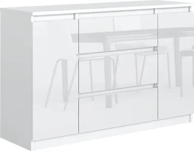 A white, high-gloss sideboard with three drawers and a cabinet door, shown from a three-quarter angle against a white background. The reflection of a dining table and chairs is visible on the glossy surface.