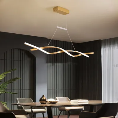 A modern dining room with a table and chairs, illuminated by a stylish pendant light.