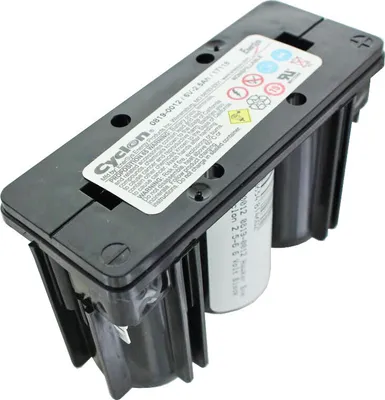 A close-up, slightly angled view of a black battery pack with a white label on top.