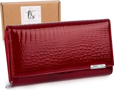 A red patent leather wallet with a crocodile texture is displayed in front of a cardboard box with a logo.