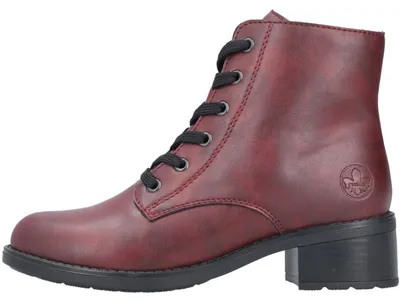 Auf dem Bild ist ein roter Stiefel zu sehen der von der linken Seite abgebildet ist. Der Stiefel hat eine glänzende Oberfläche und eine robuste Sohle.