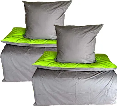 Two sets of bedding, each with a duvet cover and pillows, are neatly stacked against a white background.