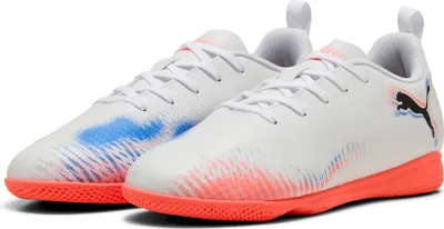 A pair of white Puma soccer shoes with orange soles and colorful accents.
