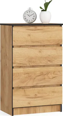 A dresser with four drawers and a clock and a plant on top.
