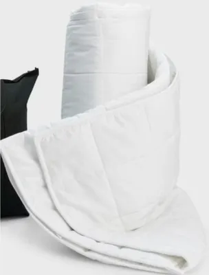 A white weighted blanket is rolled up and displayed against a white background.