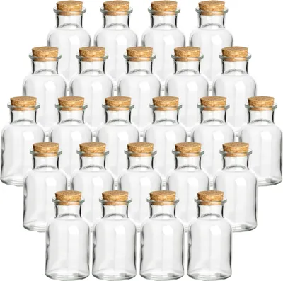 A collection of small, clear glass bottles with cork stoppers, arranged in rows.
