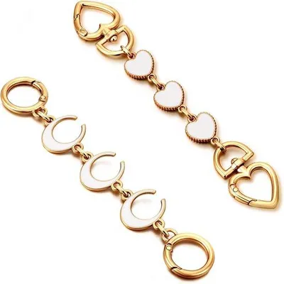 Productafbeelding van Hart- en maanmotieven tasstandaard in goud - 2 stuks. Handtasverlengstukken met zilveren ketting - witte accessoire voor schouderbanden.