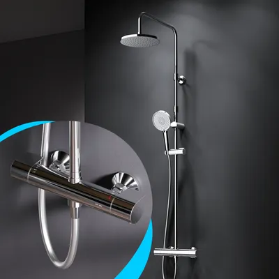 A modern chrome shower system with a rain shower head and a handheld shower head, mounted on a dark gray wall. A close-up inset shows the thermostat control.