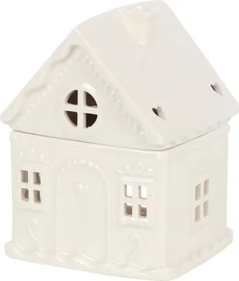 A white ceramic gingerbread house-shaped oil burner is shown from a side-front angle against a white background.