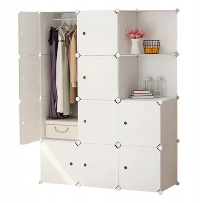 A white modular wardrobe with clothes hanging inside and decorative items on shelves.