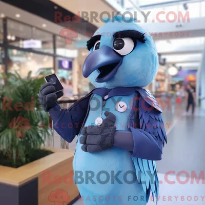 Obrázok produktu pre Maskot spoločnosti REDBROKOLY, modrá vraníková postavička, oblečená vestou a s inteligentnými hodinkami