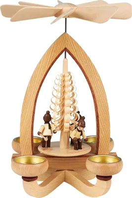 Auf dem Bild ist eine hölzerne Teelichtpyramide mit Wintersportfiguren zu sehen die um einen spiralförmigen Baum angeordnet sind und von einem Propeller gekrönt werden während vier Teelichthalter an den Ecken platziert sind