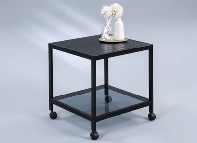 A black metal side table with a glass shelf and wheels.