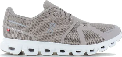 A side view of a gray and white running shoe.