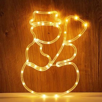 A lit-up snowman decoration against a wooden background.