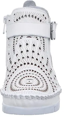 A white leather boot with intricate cut-out detailing.
