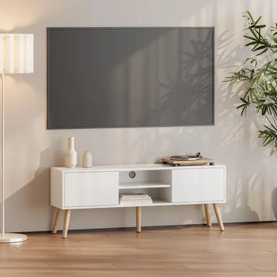 A white TV stand with a television mounted on the wall above it, in a well-lit room.