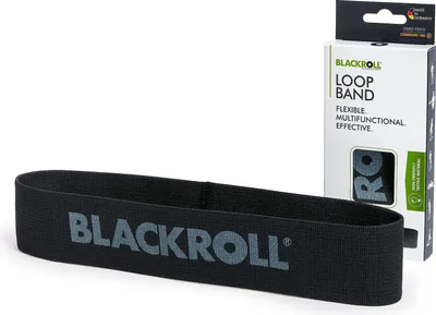 A black loop band with the brand name 'BLACKROLL' printed on it, placed in front of its retail packaging.