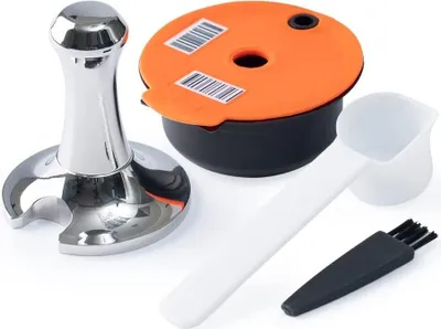 A set of coffee capsule accessories including a tamper, a refillable capsule with lid, a scoop, and a cleaning brush.