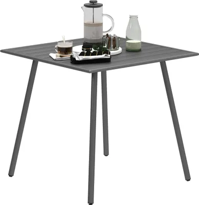 A gray square outdoor table with a French press, a cup of coffee, and a bottle of milk on it.
