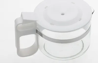 Close-up studio shot of a white coffee pot lid and glass carafe handle.