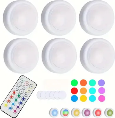 A collection of LED puck lights and a remote control.