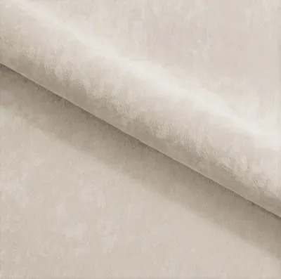 A close-up view of a folded piece of cream-colored velour fabric.