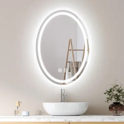 A modern bathroom vanity with a lit oval mirror above a sink.