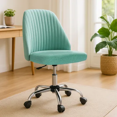 A teal office chair with a silver base and wheels is shown in a well-lit room with a wooden desk and a potted plant.