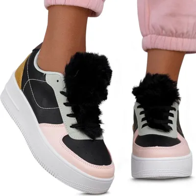 A pair of women's sneakers with fur accents, worn by a person.
