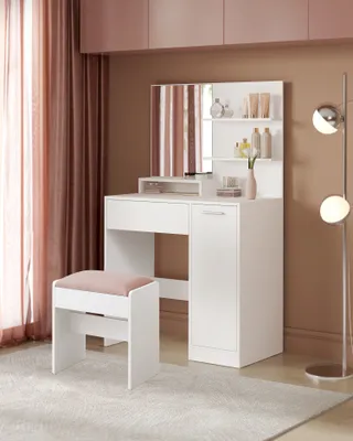A white vanity set with a mirror and stool in a room with pink and brown accents.