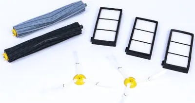 A set of replacement parts for an iRobot Roomba vacuum cleaner, including brushes and filters, laid out on a white background.