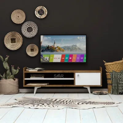 A modern living room setup featuring a TV stand with a television, decorative baskets, and a plant.