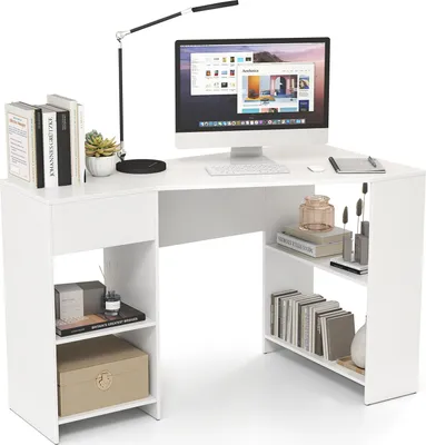 A white L-shaped desk with a computer, lamp, books, and decorative items.