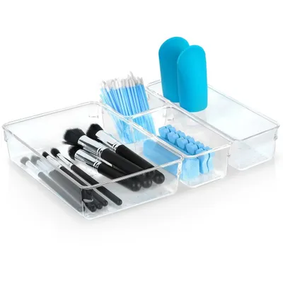 A set of clear acrylic organizers filled with makeup brushes, cotton swabs, and other beauty tools.